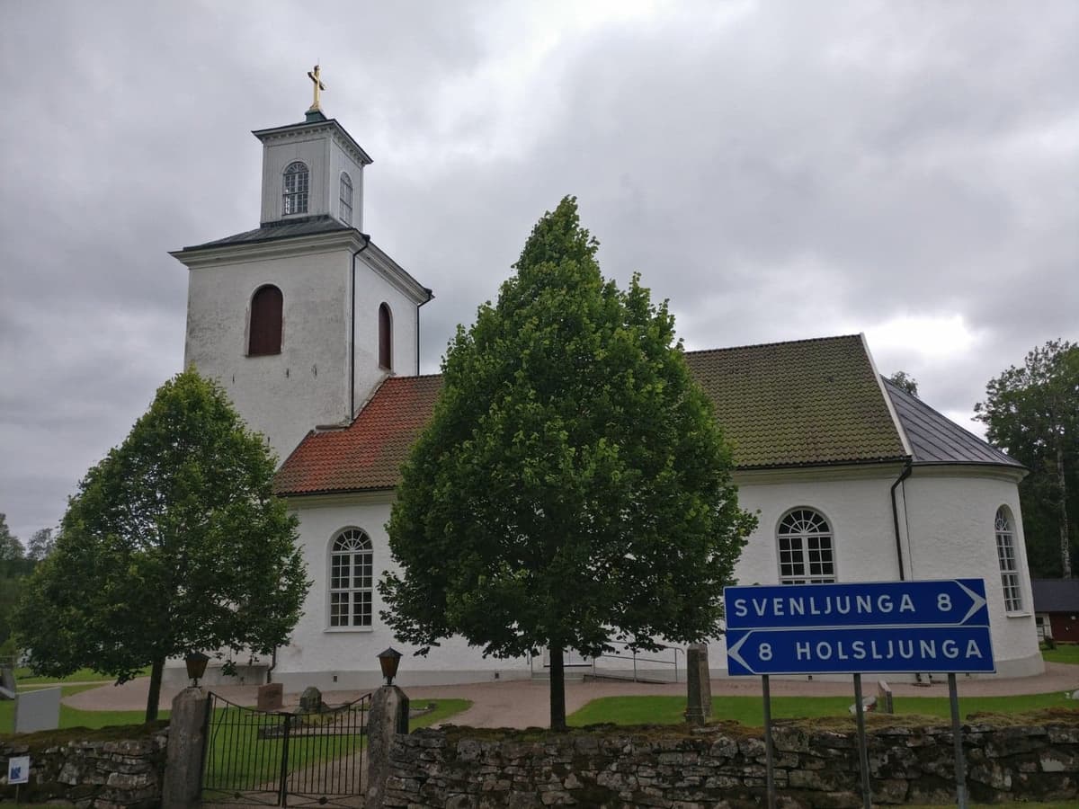 En kyrka bakom två träd.